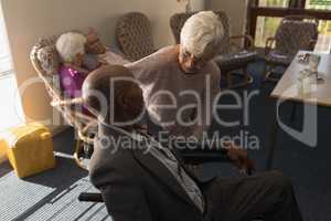 Senior woman talking with disable senior man at nursing home