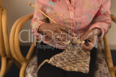 Senior woman knitting with yarn at home