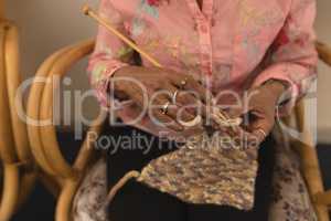 Senior woman knitting with yarn at home