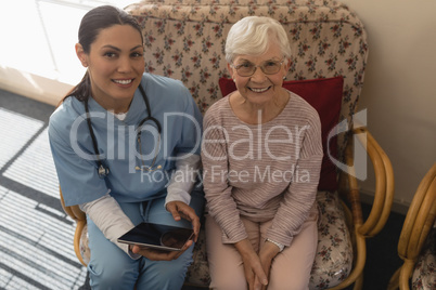 High angle view of female doctor and senior woman looking at camera