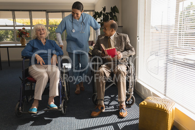 Front view of female doctor talking with disable senior couple at home