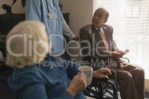 Disable senior couple talking with doctor at home