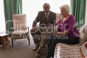 Front view of senior couple using laptop on sofa