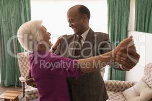 Happy senior couple dancing together at home