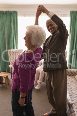 Happy senior couple dancing together at home