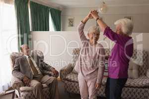 Front view of senior friends dancing together at home