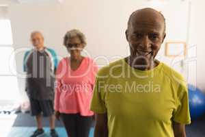 Front view of senior friends looking at camera in fitness studio