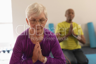 Senior woman doing yoga in fitness studio