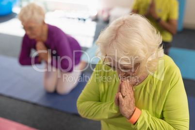 Senior woman doing yoga in fitness studio