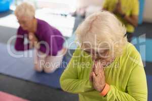 Senior woman doing yoga in fitness studio