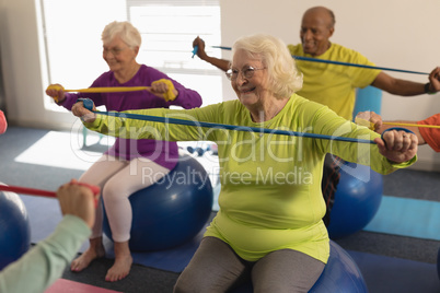 Senior people exercising with resistance band in fitness studio