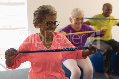 Senior woman exercising with resistance band in fitness studio