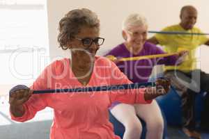 Senior woman exercising with resistance band in fitness studio