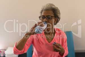 Senior woman drinking water after workout