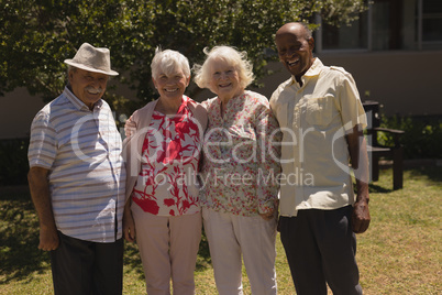 Front view of senior friends looking at camera in garden