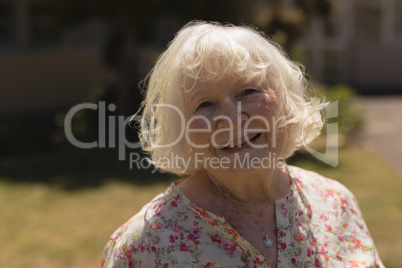 Front view of senior woman looking at camera in garden