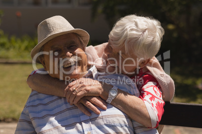 Front view of senior woman embracing senior man in garden