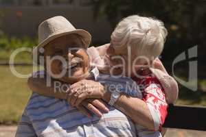 Front view of senior woman embracing senior man in garden