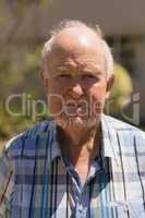 Close- up of senior man looking at camera in garden