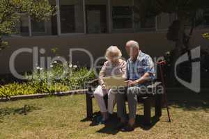 Front view of senior couple using laptop in garden