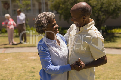 Side view of senior couple dancing together in garden