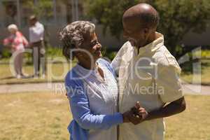 Side view of senior couple dancing together in garden