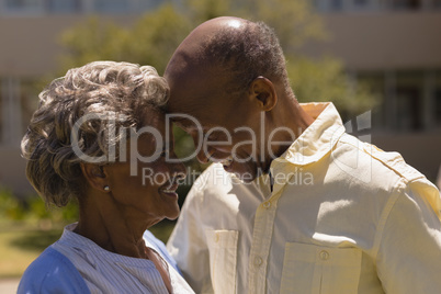 Side view of senior couple head to head in garden Side view of senior couple head to head in garden