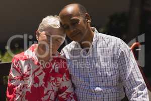 Front view of senior couple head to head with eyes closed in garden