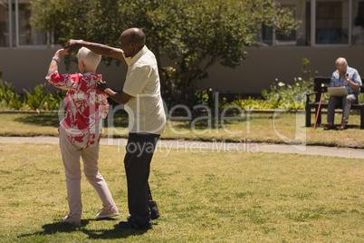 senior couple dancing together in garden