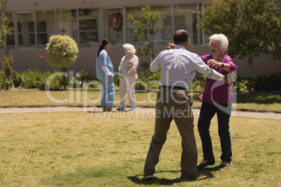 Senior couple dancing together in garden
