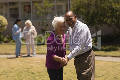 senior couple dancing together in garden