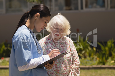 young female doctor discussing medical report with senior woman