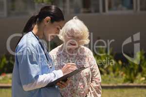 young female doctor discussing medical report with senior woman