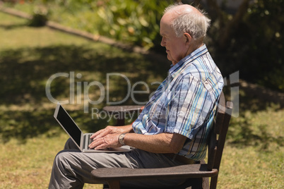 Senior man using laptop in the park