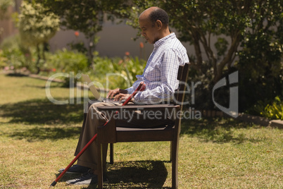 Senior man using laptop in the park