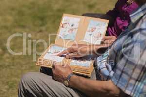 Senior couple looking at photo album in the park