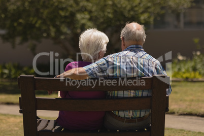 Senior couple sitting together on the bench in the park