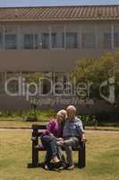 Senior couple sitting together on the bench in the park