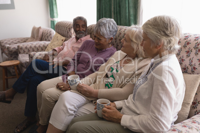 Senior people having coffee in living room