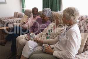 Senior people having coffee in living room