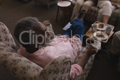 Senior man having black coffee in living room