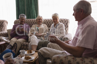Senior people having coffee in living room