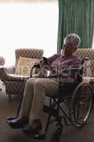 Disabled senior woman using mobile phone in living room