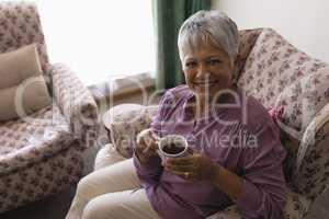 Senior woman having black coffee in living room