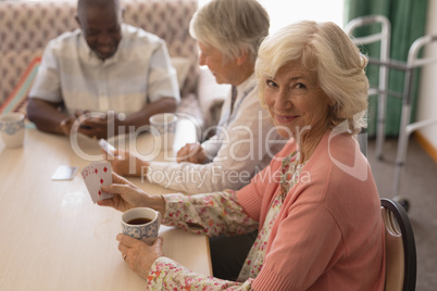 Senior woman playing cards in living room