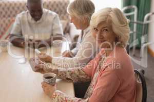 Senior woman playing cards in living room