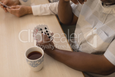 Senior man playing cards in living room