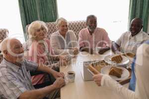 Group of senior people having black coffee in living room