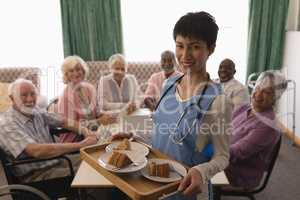Female doctor holding tray of cake at home