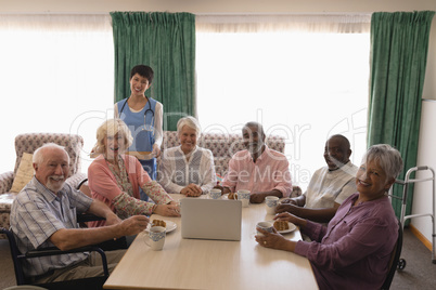 Female doctor standing with senior people at home